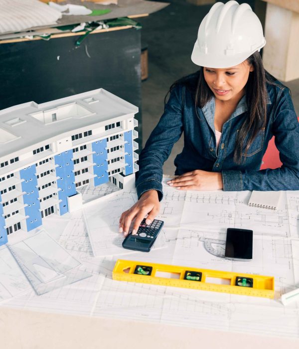 african-american-lady-safety-helmet-sitting-near-model-building (1)